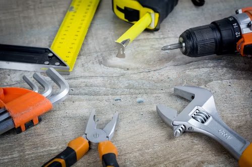 A photo showing various tools resting on a wood surface