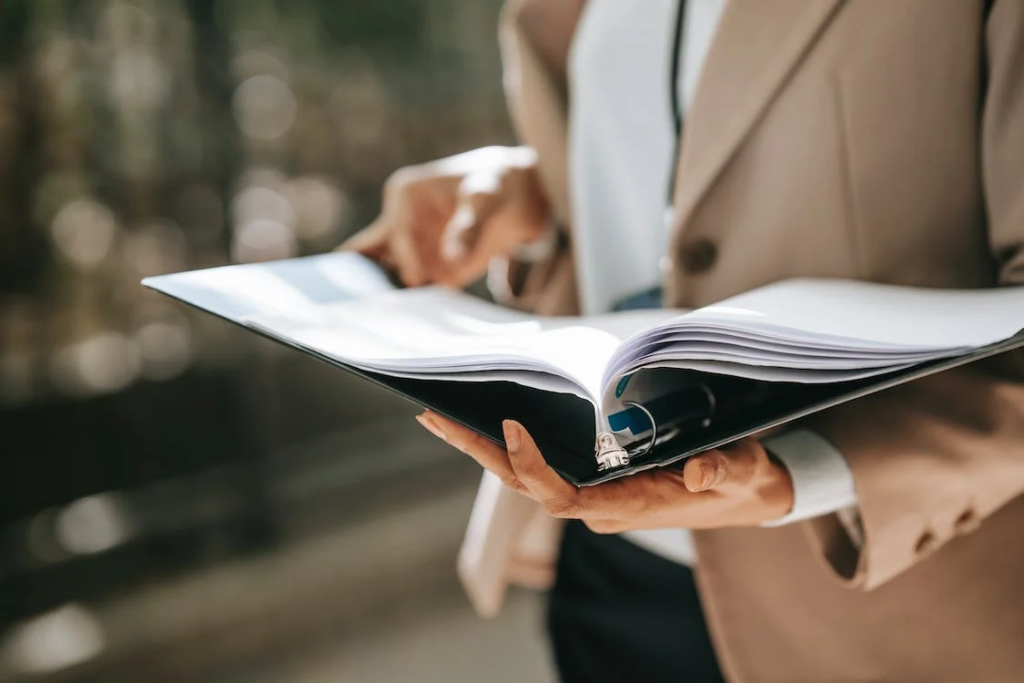 A photo showing a woman holding a folder.