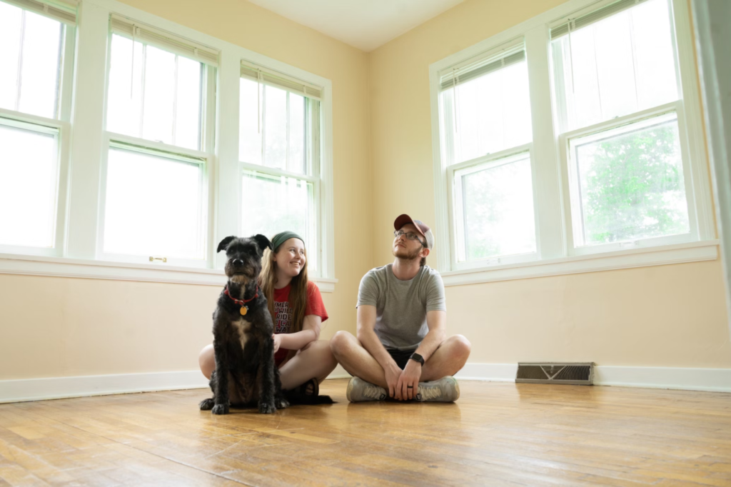 A photo showing two people sitting with a dog.