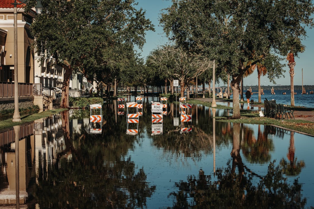 A photo showing a flooded street with warning signs