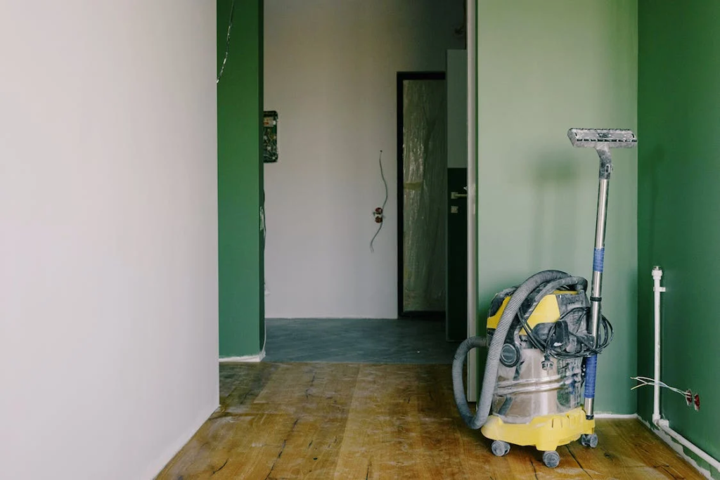 A photo showing a vacuum cleaner in a room with green walls