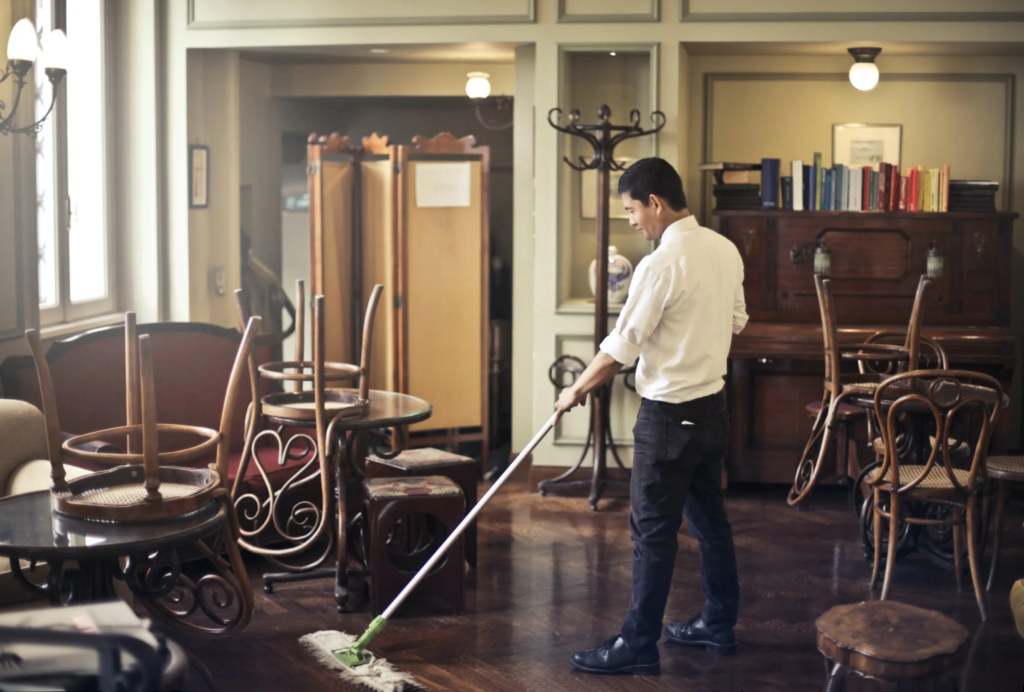 A photo showing a man mopping a floor