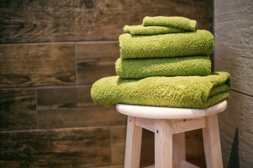 A photo showing a stack of green towels on a stool.