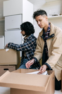 A photo showing two people placing items in boxes.