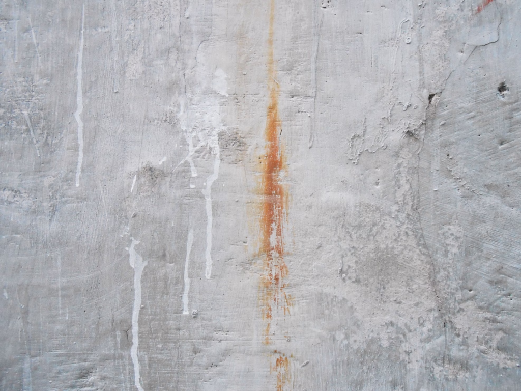 A photo showing a wall with rust stains.