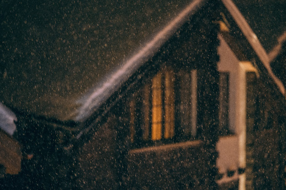 View of snow falling over a house