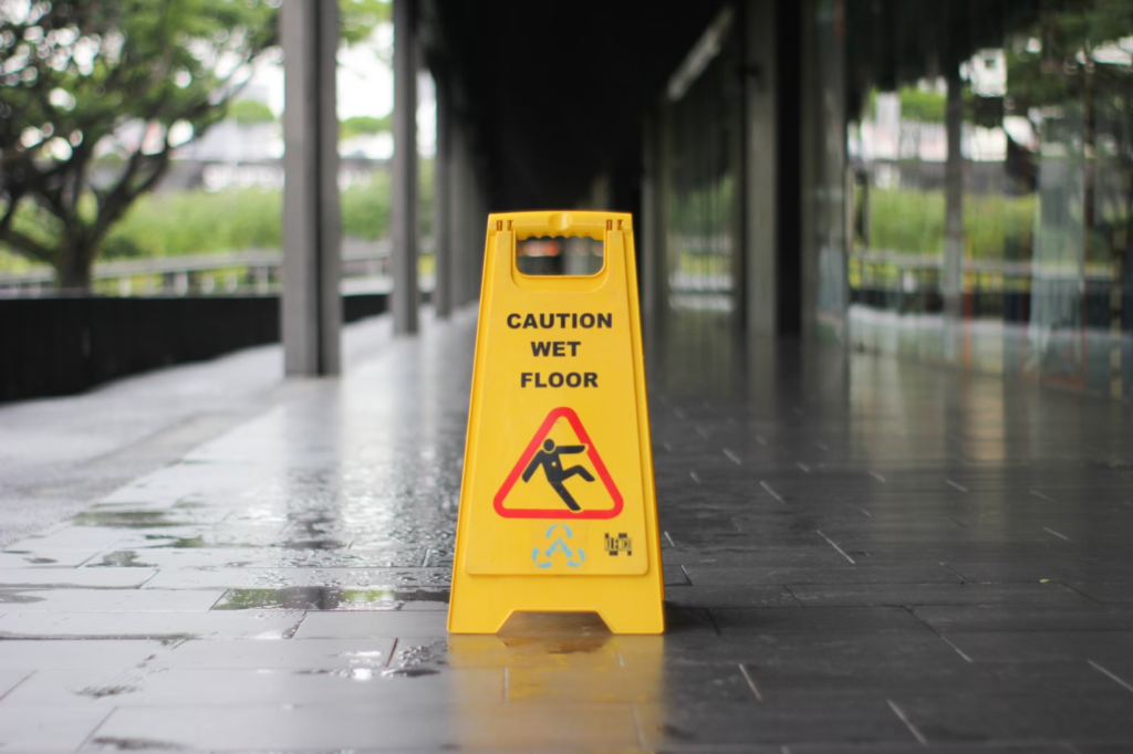 A photo showing a wet floor sign near a building entrance.