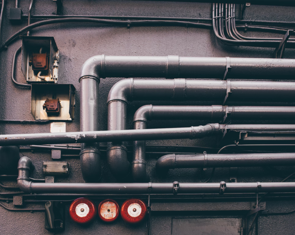 A photo showing metal pipes running along a wall.