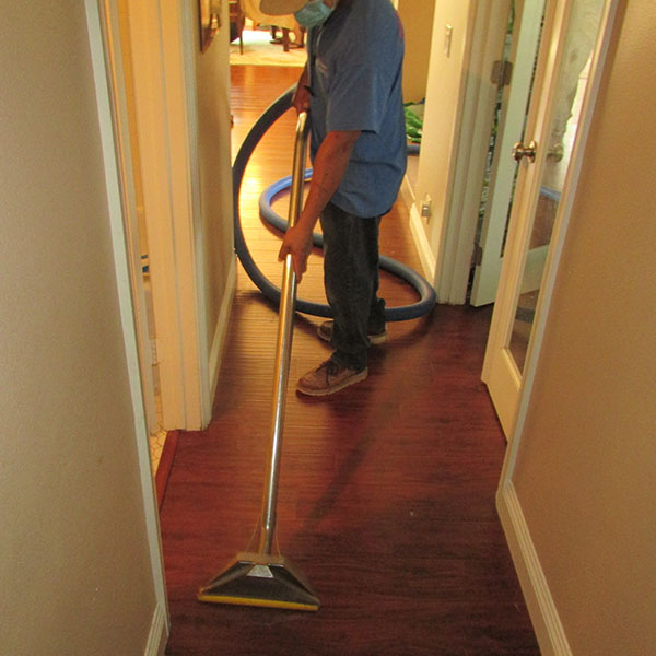 A man vacuuming by https://localprowaterdamage.com/wp-content/uploads/2023/07/9.jpg