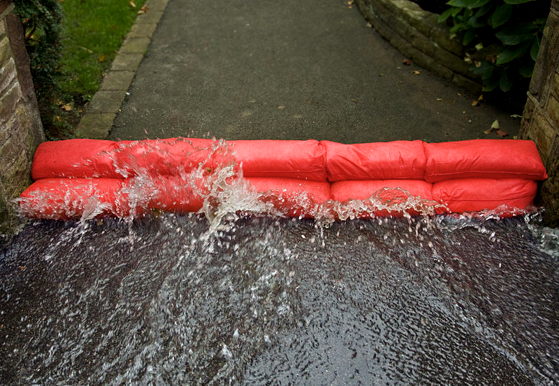 A home with flood barriers by https://commons.wikimedia.org/wiki/File:Hydrosnake_low_level_flood_Barricade.jpg